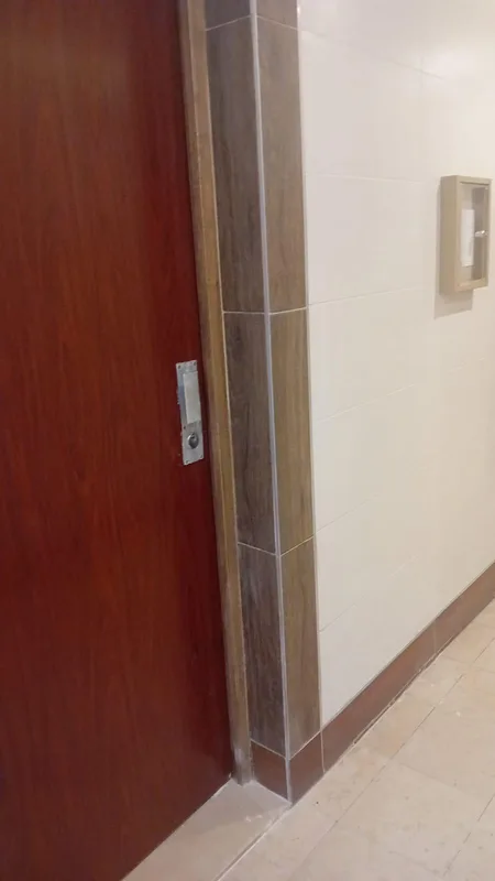 Gâche métallique posée sur porte palière en bois